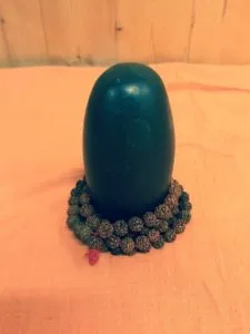 shiva lingam entouré d'un mala de rudraksha